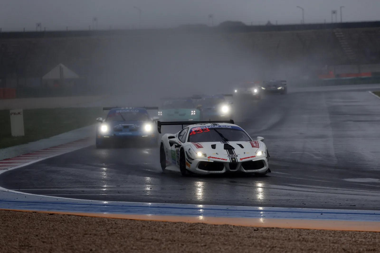 No. 433 running with headlights on through heavy spray at Misano
