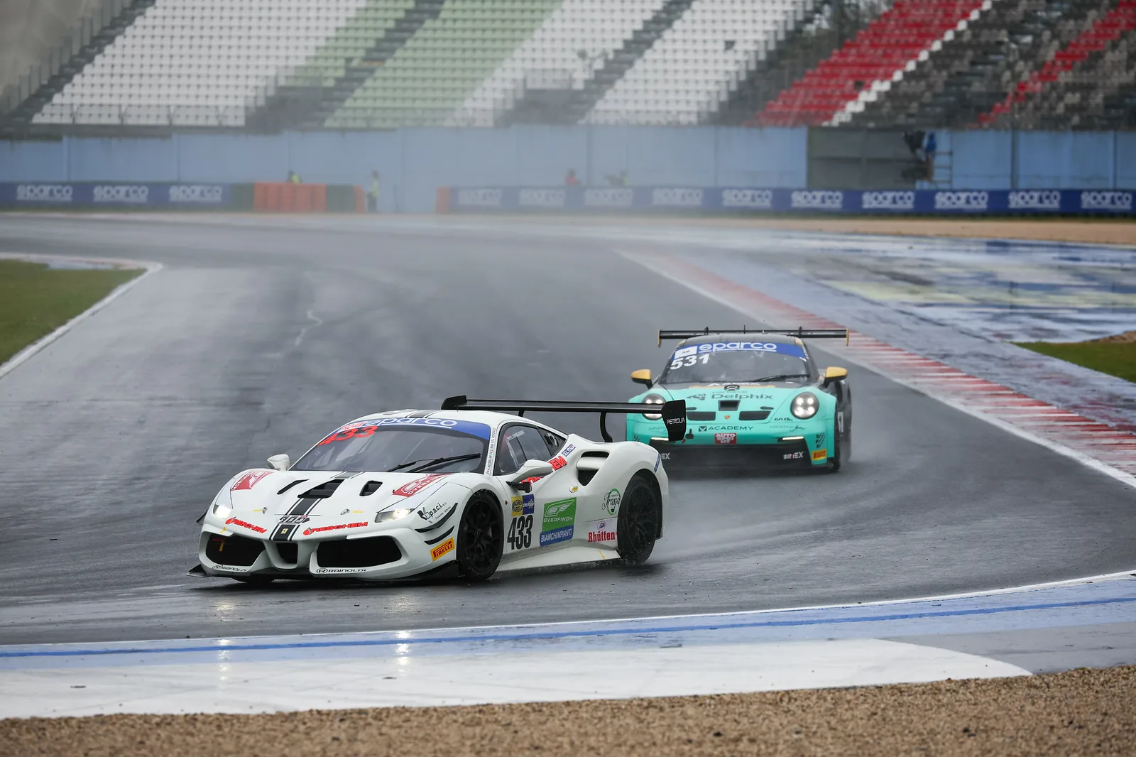 No. 433 leading a Porsche through a wet corner at Misano